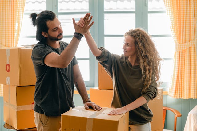 two people high fiving over moving boxes
